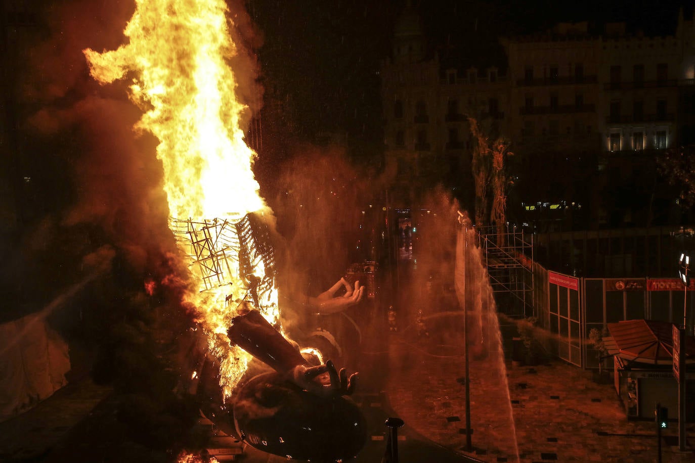 Los bomberos hacen arder la parte ya plantada de la falla del Ayuntamiento. La cabeza de la chica se guardará para la celebración de julio.