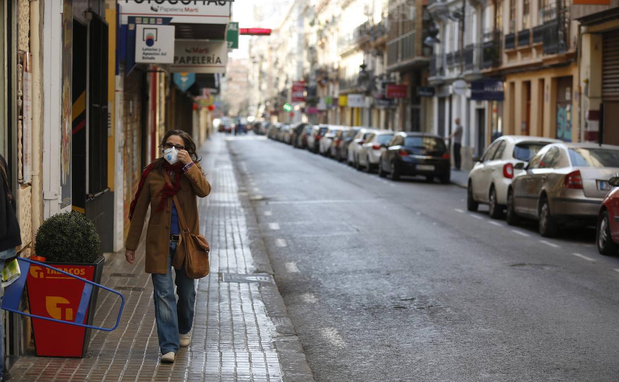 Una mujer circula por una calle de Valencia tras la declaración de estado de alerta.