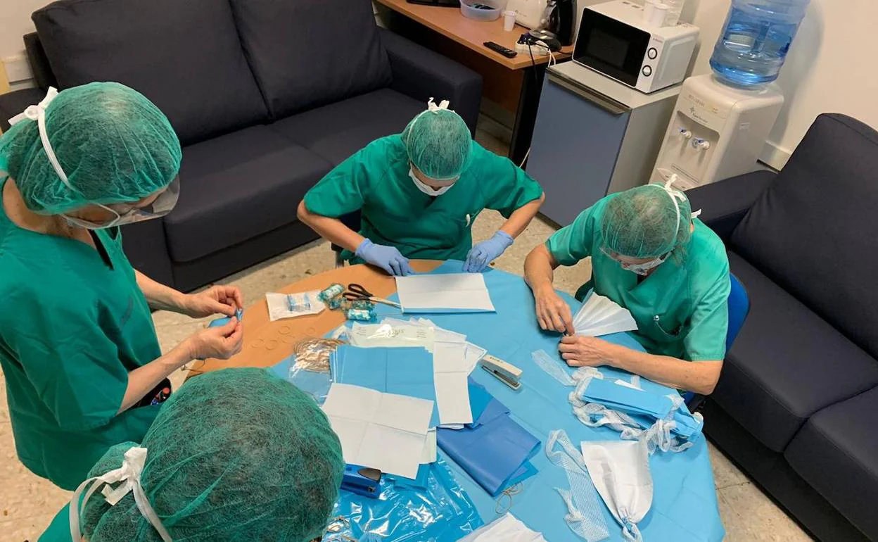 Personal sanitario de un hospital valenciano, mientras fabrica algunas mascarillas.
