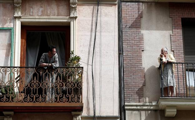 Dos vecinos conversan desde sus balcones en Madrid durante el confinamiento por el estado de alarma