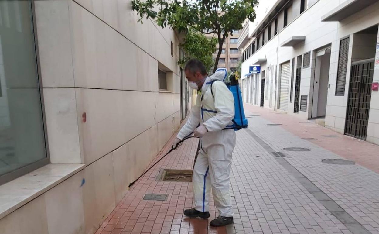 Un trabajador limpia la fachada de la residencia Santa Elena. 