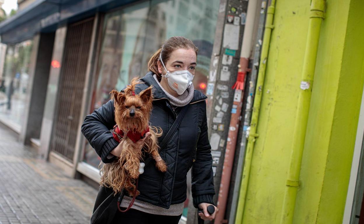 Una vecina de Valencia saca a su mascota a la calle durante el confinamiento