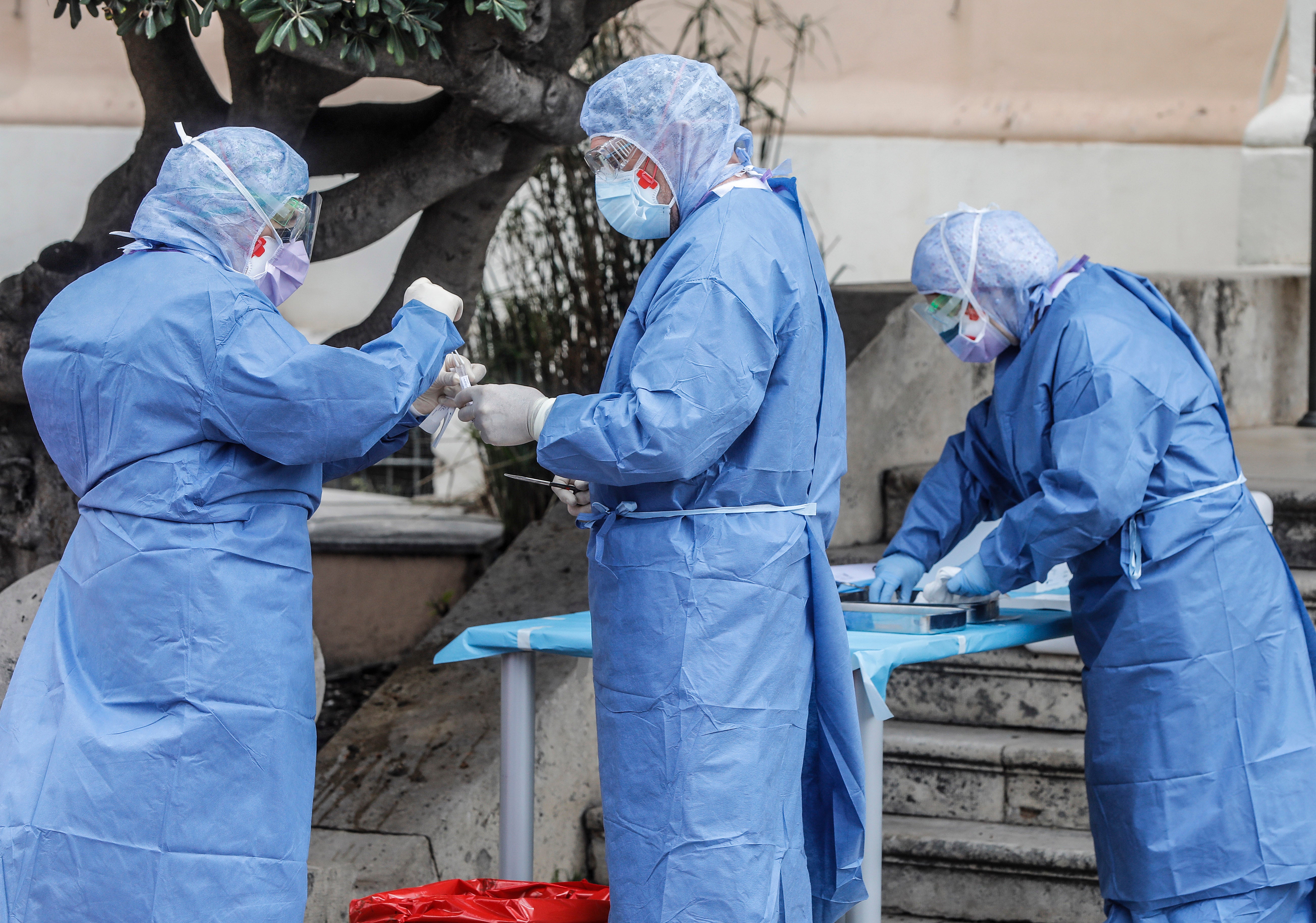 Miembros del hospital de la Malvarrosa, en Valencia, realizan tomas de muestra rápidas al personal sanitario sin que los conductores bajen del vehículo. 