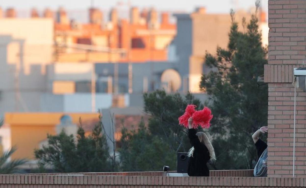 Dos personas aplauden desde el balcón en Valencia. 