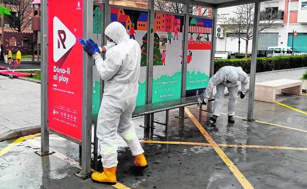 Operarios limpiando una marquesina de conexión con el metro.