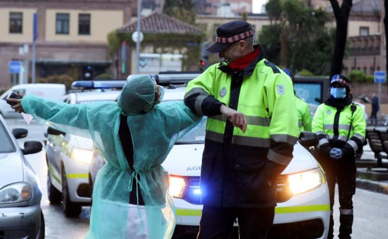 Un sanitario y un policía se saludan con el codo.