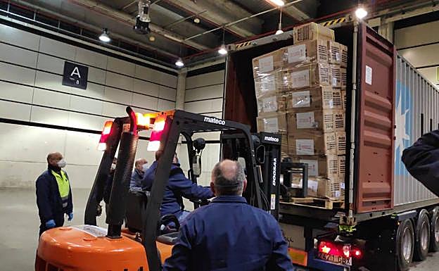 Operarios sacan del camión el material sanitario. 