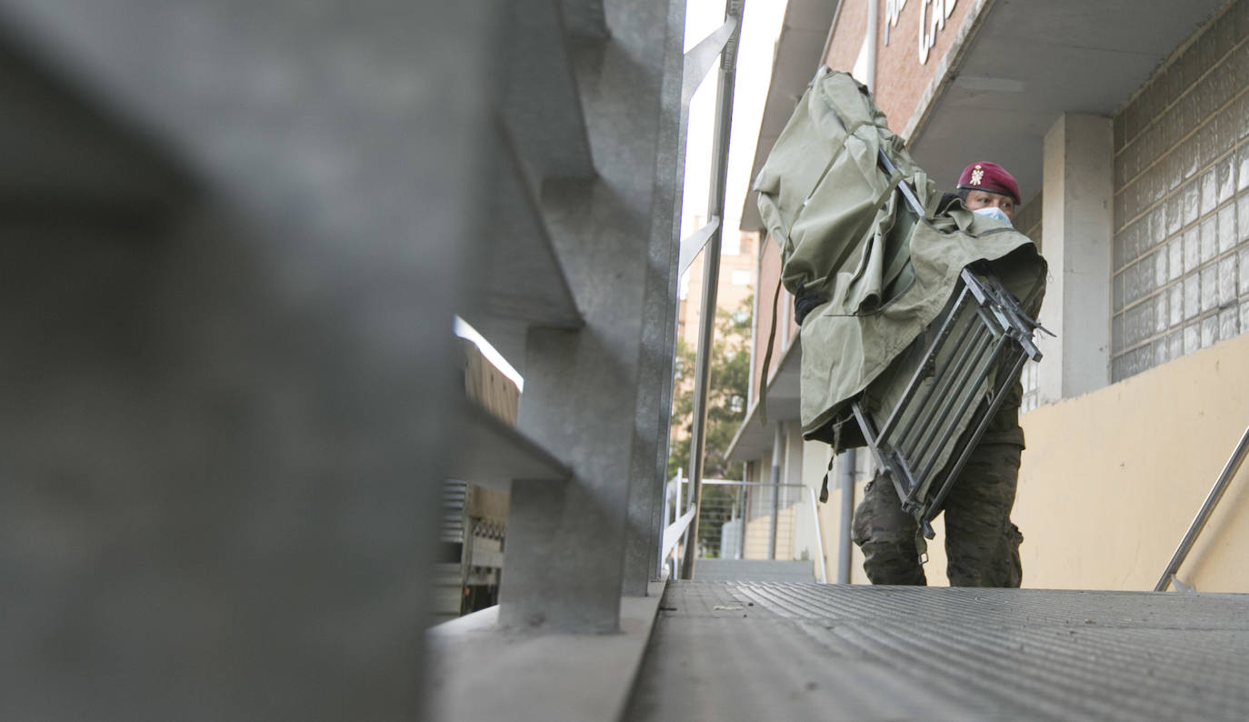 Militares del ejército colocan los materiales necesarios para adecuar el polideportivo del Cabanyal en un albergue para personas sin techo. 