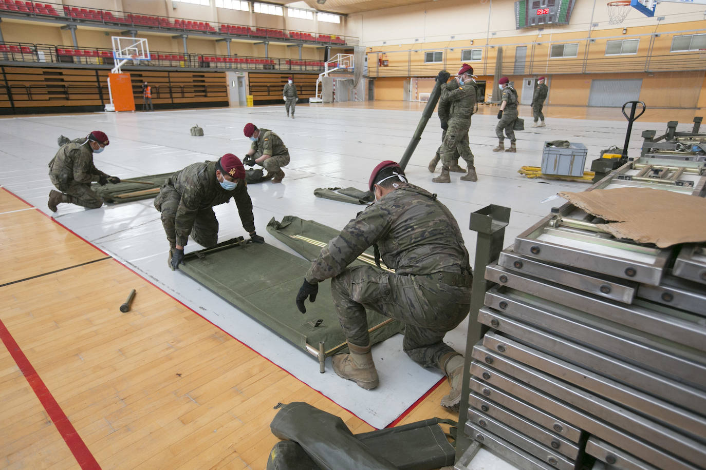 Militares del ejército colocan los materiales necesarios para adecuar el polideportivo del Cabanyal en un albergue para personas sin techo.