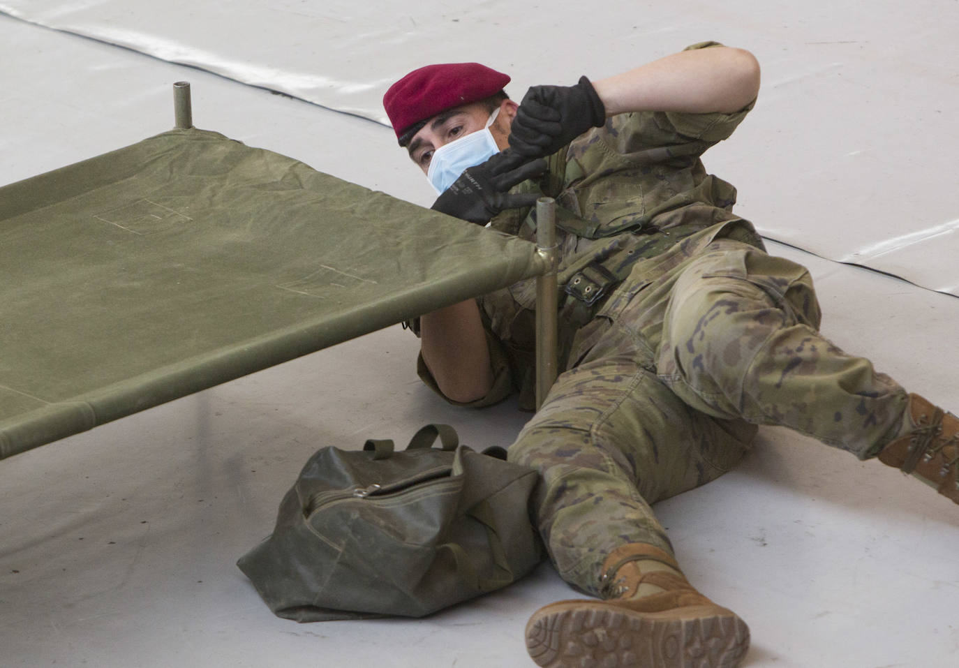 Militares del ejército colocan los materiales necesarios para adecuar el polideportivo del Cabanyal en un albergue para personas sin techo.