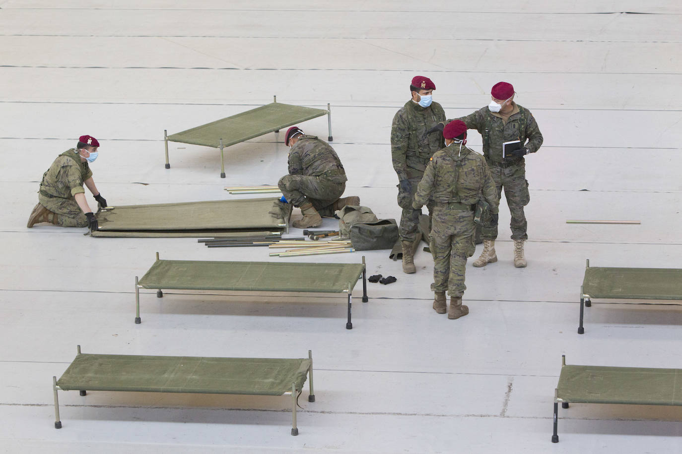 Militares del ejército colocan los materiales necesarios para adecuar el polideportivo del Cabanyal en un albergue para personas sin techo. 