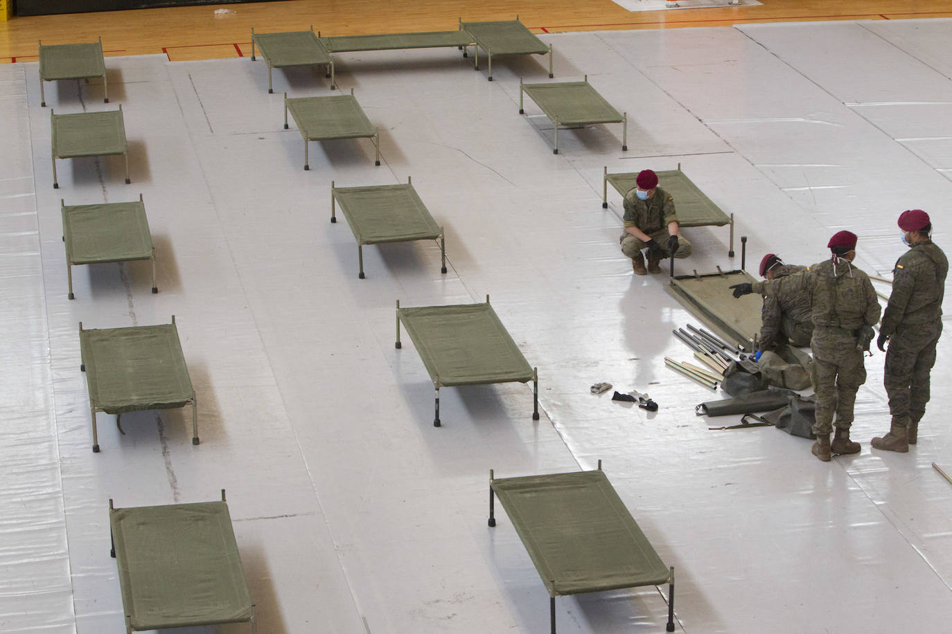 Militares del ejército colocan los materiales necesarios para adecuar el polideportivo del Cabanyal en un albergue para personas sin techo.