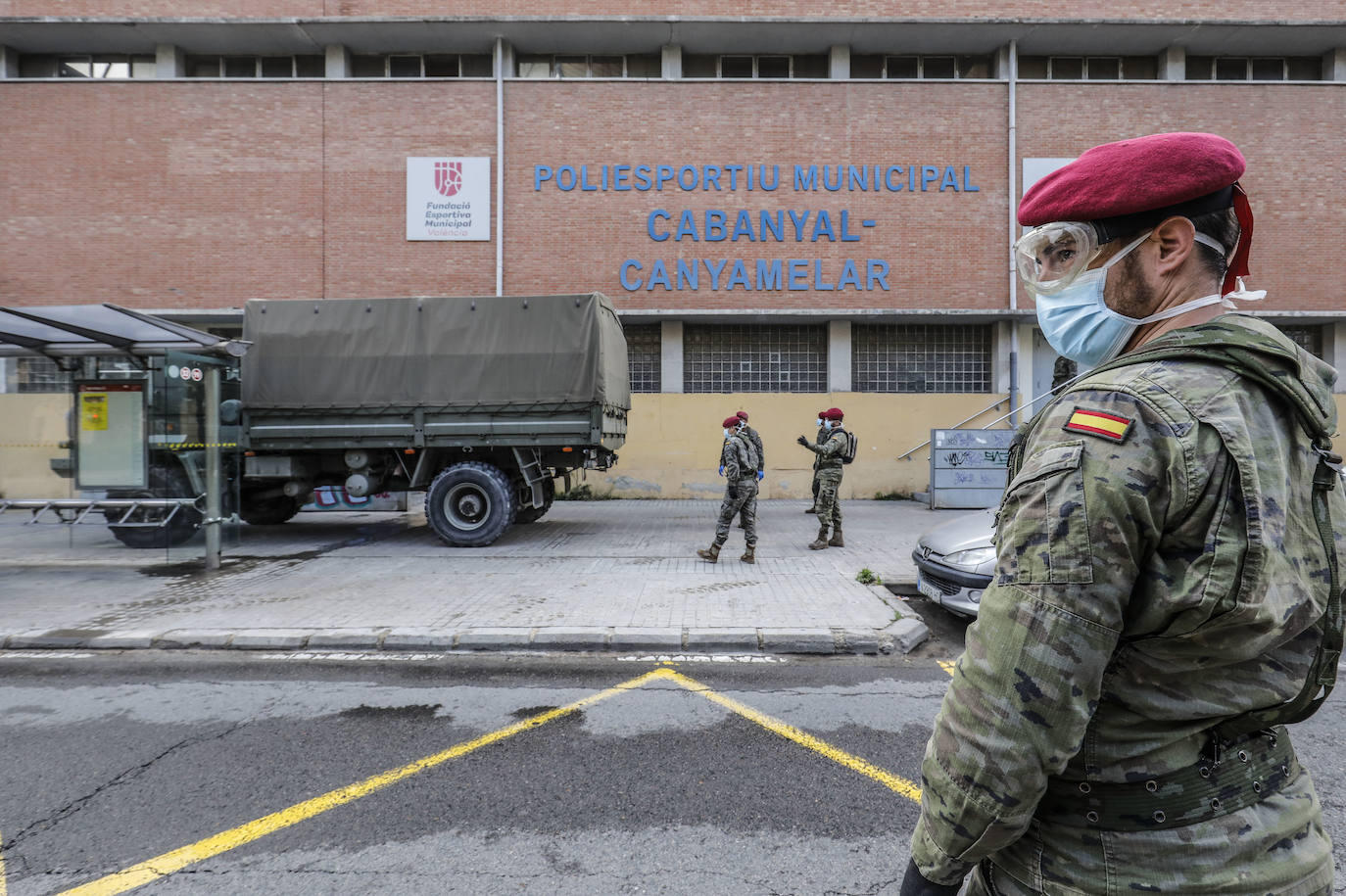 Militares del ejército colocan los materiales necesarios para adecuar el polideportivo del Cabanyal en un albergue para personas sin techo.