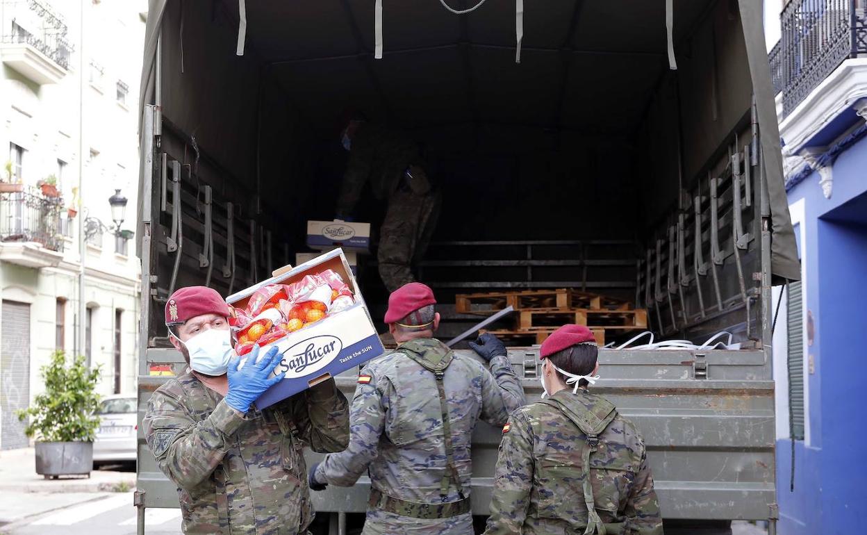 Un grupo de militares descarga ayer cajas de naranjas y mandarinas en Casa Caridad. 