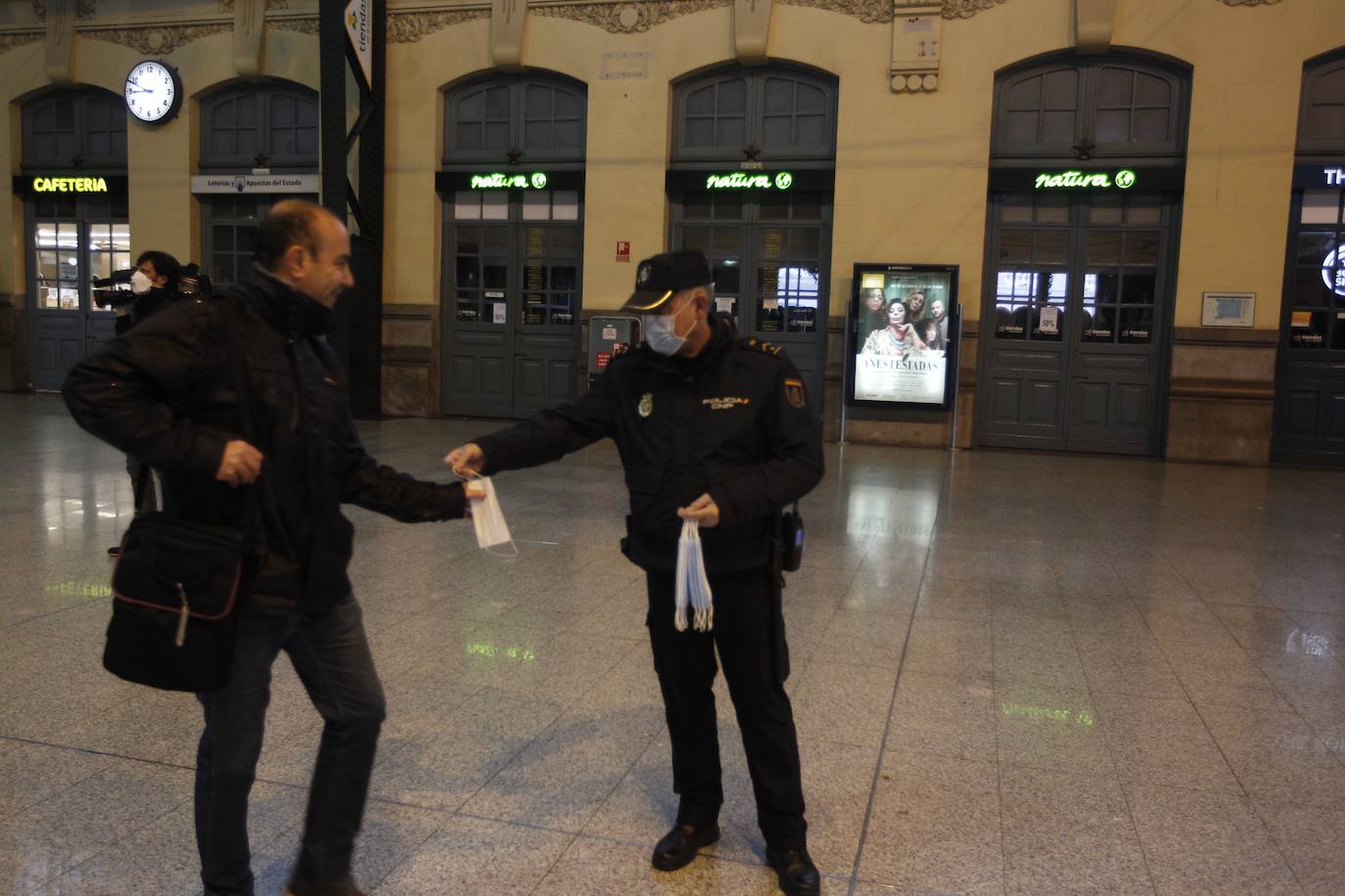 Policías y guardias civiles distribuyen mascarillas en estaciones de tren, cercanías, metros y autobuses a las personas que emplean el transporte público para acudir a sus puestos de trabajo en el primer día laborable tras la Semana Santa. 