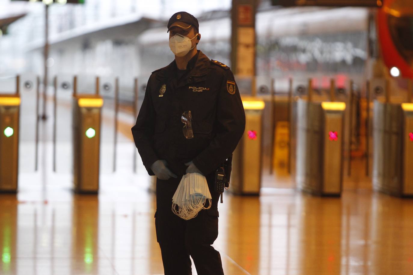 Policías y guardias civiles distribuyen mascarillas en estaciones de tren, cercanías, metros y autobuses a las personas que emplean el transporte público para acudir a sus puestos de trabajo en el primer día laborable tras la Semana Santa. 