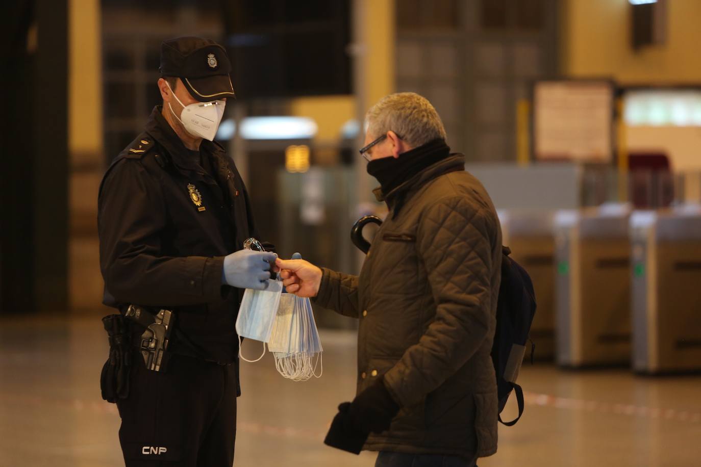 Policías y guardias civiles distribuyen mascarillas en estaciones de tren, cercanías, metros y autobuses a las personas que emplean el transporte público para acudir a sus puestos de trabajo en el primer día laborable tras la Semana Santa. 