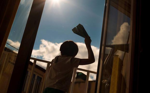 Un niño se entretiene en la terraza de su casa. 