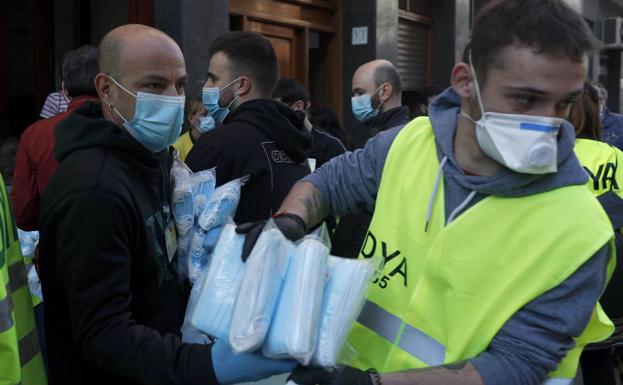 Voluntarios hacen acopio de mascarillas para repartir a la población. 