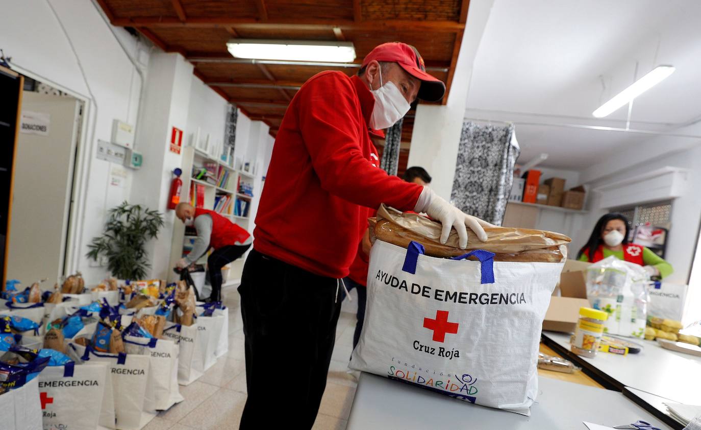 Voluntarios de Cruz Roja preparan las bolsas con productos de primera necesidad para repartir entre las personas que se encuentran en situaciones de dificultad