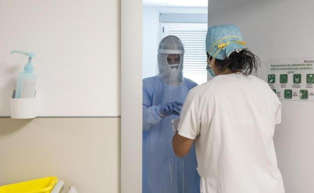 Trabajadores sanitarios entran en la habitación de un paciente negativo de Covid-19 en el Hospital Arnau de Vilanova.