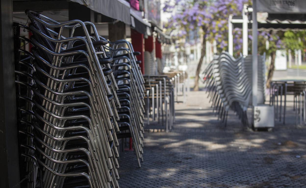 Sillas apiladas en la terraza de un bar.