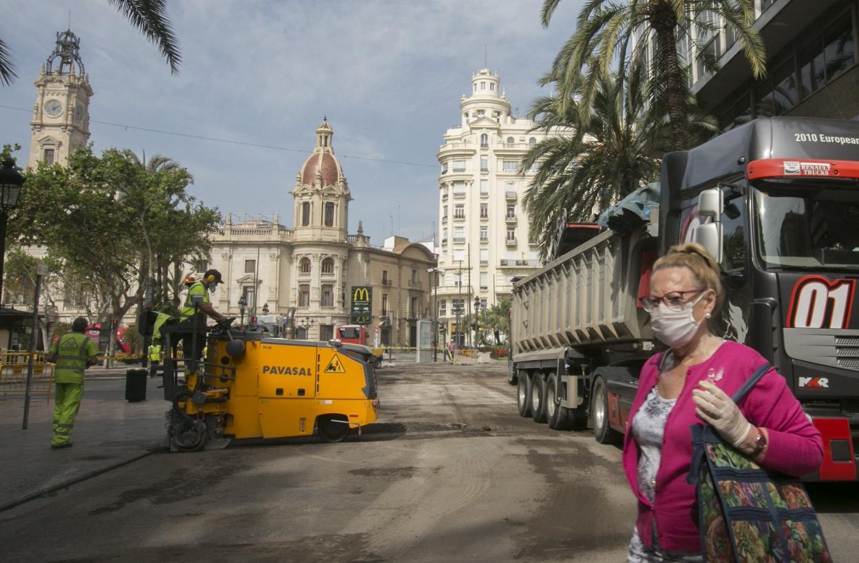 t Una nueva plaza. Una viandante cruza la plaza del Ayuntamiento mientras es reasfaltada, ayer. damián torres