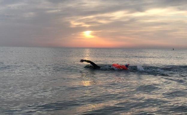 Un deportista nada el la playa en Valencia. 