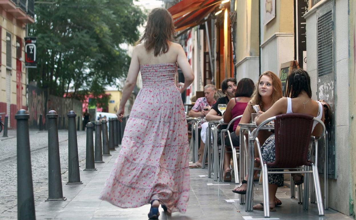 Una viandante pasa junto a una terraza del centro histórico. 