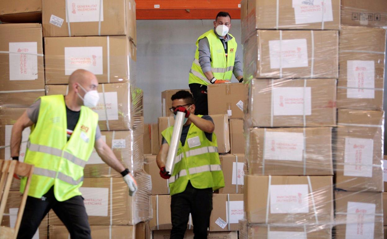 Operarios descargan material comprado por la Generalitat. 