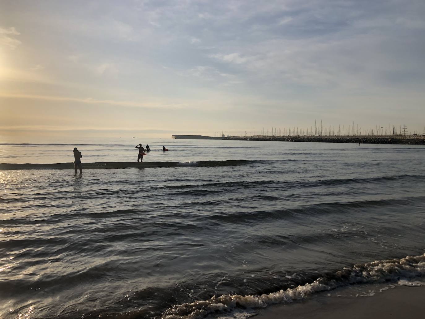 Nadadores, corredores, surfistas y personas practicando yoga se han dejado ver este jueves en las playas de Valencia desde que se ha asomado el sol, aprovechando las horas permitidas para practicar deporte en la ciudad. 