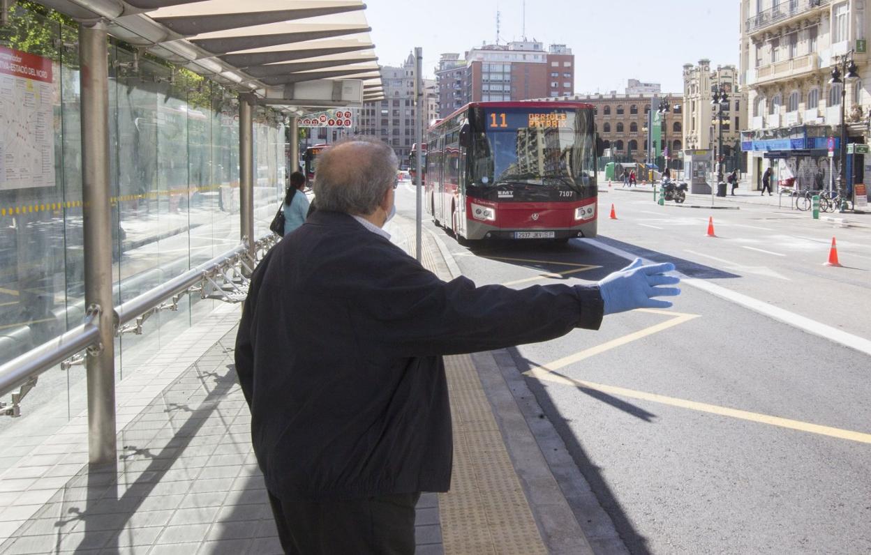 Un usuario da el alto a un autobús de la EMT en el centro. damián torres