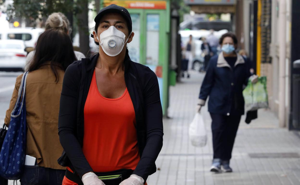 Una mujer pasea por Valencia esta mañana