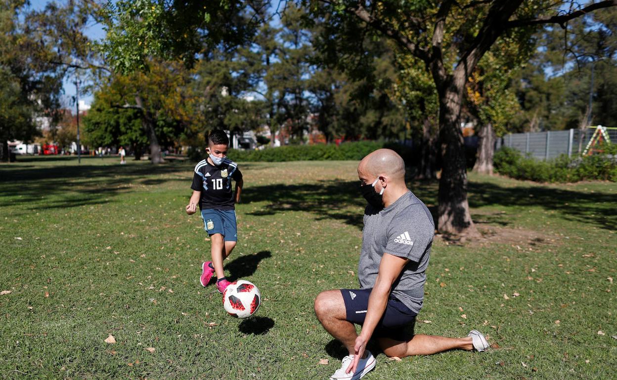 Un padre y su hijo juegan al fútbol en un parque de Buenos Aires. 