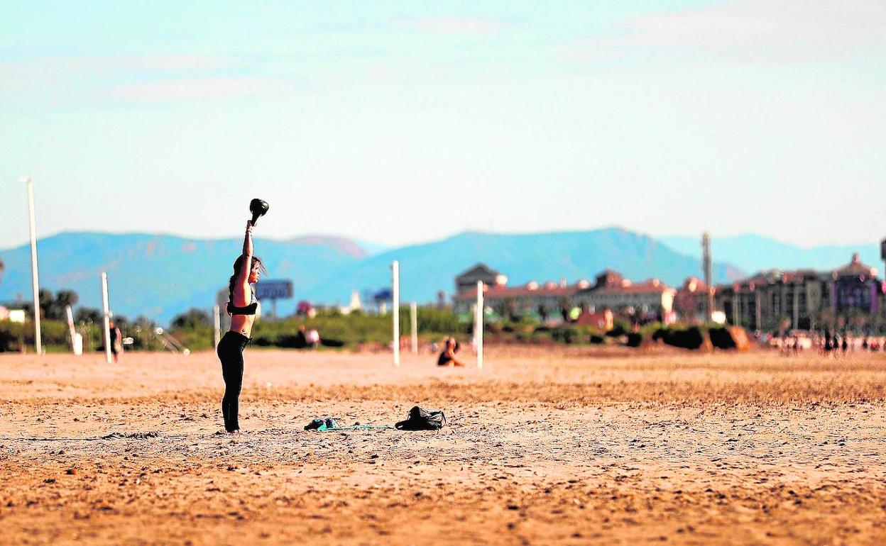 Una mujer hace ejercicio en la playa de La Patacona de Alboraya, ayer.