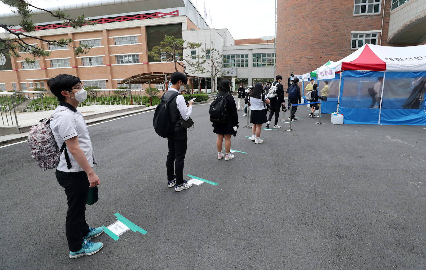 Corea del Sur, uno de los primeros países infectados por el coronavirus que surgió en la ciudad china de Wuhan, está recuperando poco a poco la normalidad. Muestra de ello ha sido el regreso a las clases de sus estudiantes. Los primeros en volver a los pupitres han sido los alumnos de bachillerato; el resto se irá incorporando poco a poco. No obstante, el inicio del curso escolar se ha hecho con una serie de medidas para evitar los contagios entre los estudiantes: el uso de mascarillas en todo momento, limpieza de los pupitres, ventilación continua de los cuartos, mámparas en el comedor y en las mesas y tomas de temperatura al entrar al colegio, todo ello, manteniendo las distancias de seguridad. 