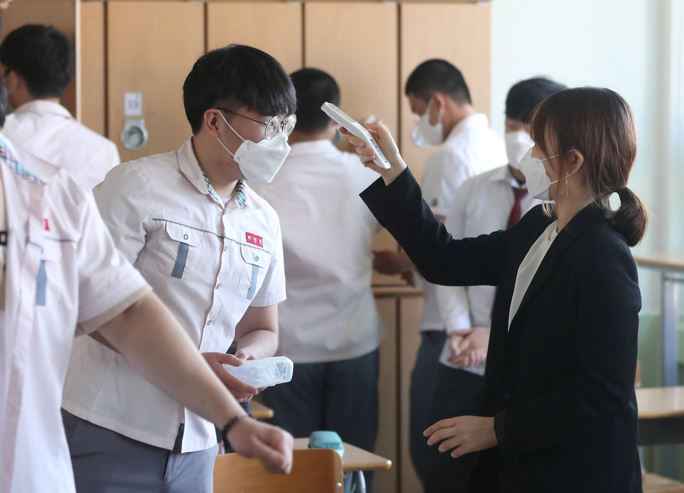 Corea del Sur, uno de los primeros países infectados por el coronavirus que surgió en la ciudad china de Wuhan, está recuperando poco a poco la normalidad. Muestra de ello ha sido el regreso a las clases de sus estudiantes. Los primeros en volver a los pupitres han sido los alumnos de bachillerato; el resto se irá incorporando poco a poco. No obstante, el inicio del curso escolar se ha hecho con una serie de medidas para evitar los contagios entre los estudiantes: el uso de mascarillas en todo momento, limpieza de los pupitres, ventilación continua de los cuartos, mámparas en el comedor y en las mesas y tomas de temperatura al entrar al colegio, todo ello, manteniendo las distancias de seguridad. 