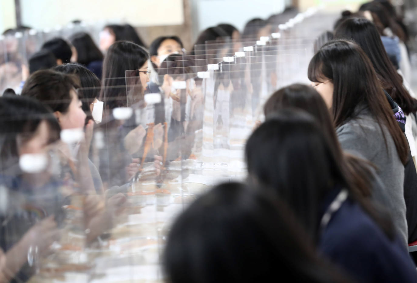 Corea del Sur, uno de los primeros países infectados por el coronavirus que surgió en la ciudad china de Wuhan, está recuperando poco a poco la normalidad. Muestra de ello ha sido el regreso a las clases de sus estudiantes. Los primeros en volver a los pupitres han sido los alumnos de bachillerato; el resto se irá incorporando poco a poco. No obstante, el inicio del curso escolar se ha hecho con una serie de medidas para evitar los contagios entre los estudiantes: el uso de mascarillas en todo momento, limpieza de los pupitres, ventilación continua de los cuartos, mámparas en el comedor y en las mesas y tomas de temperatura al entrar al colegio, todo ello, manteniendo las distancias de seguridad. 