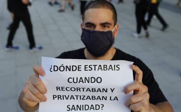 Simpatizante de un colectivo de izquierdas que protesta contra las personas que piden la dimisión del Gobierno.