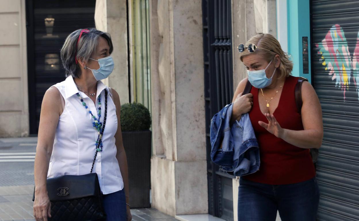 Dos mujeres con mascarilla en una calle de Valencia.