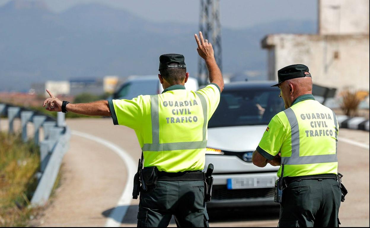 Dos agentes de Tráfico realizan un control en una carretera valenciana.