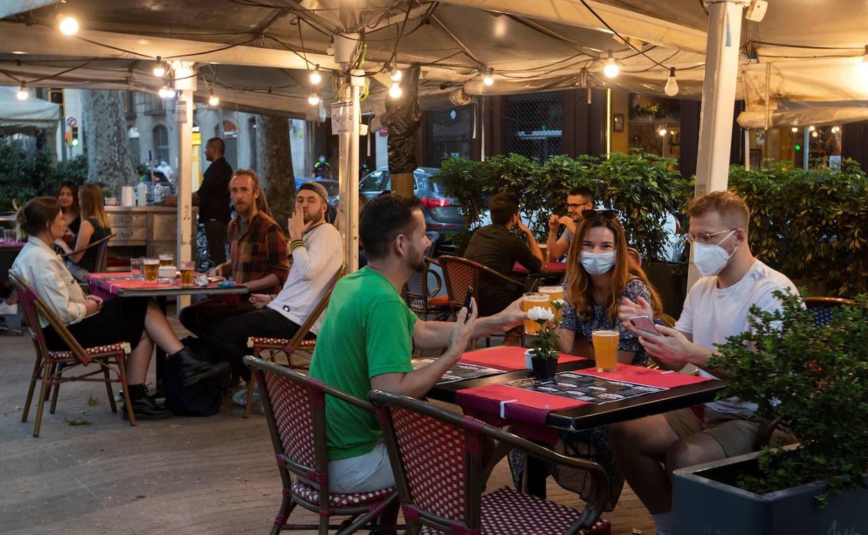 Unos jóvenes sentados en una terraza. 