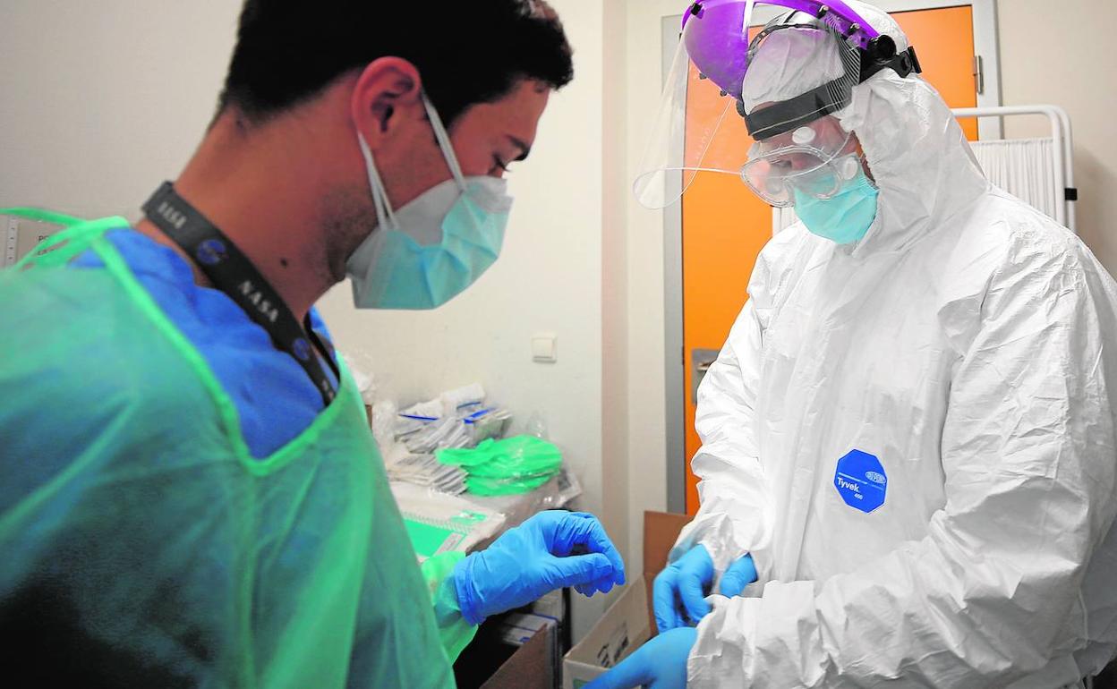 Personal sanitario del Hospital La Fe se coloca mascarillas, guantes y otras medidas de protección.