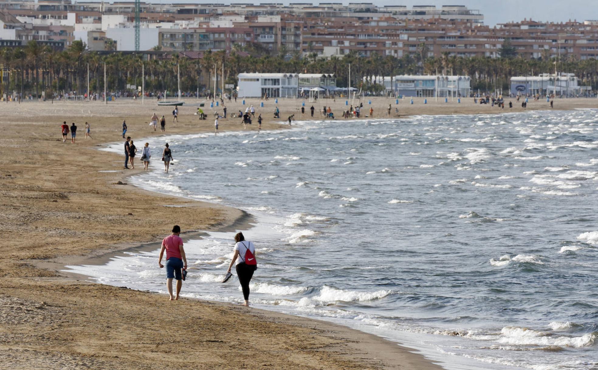 Ciudadanos pasean por una playa de la costa valenciana. 