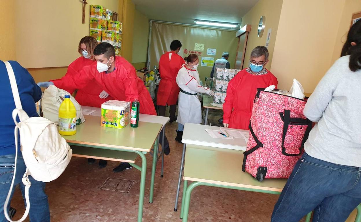 Voluntarios de Cáritas Tavernes repartiendo productos en el economato. 