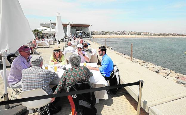 Varios clientes en la terraza del restaurante Panorama, en el espigón junto a la playa de las Arenas, en Valencia.