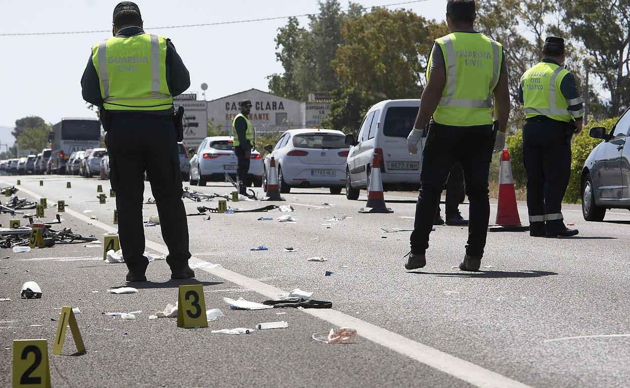 Varios guardias civiles junto a los restos de un accidente de trafico. 