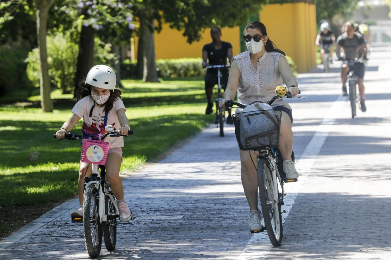 Madre e hija, en bici, ayer durante su paseo matutino por el cauce del río Turia. irene marsilla