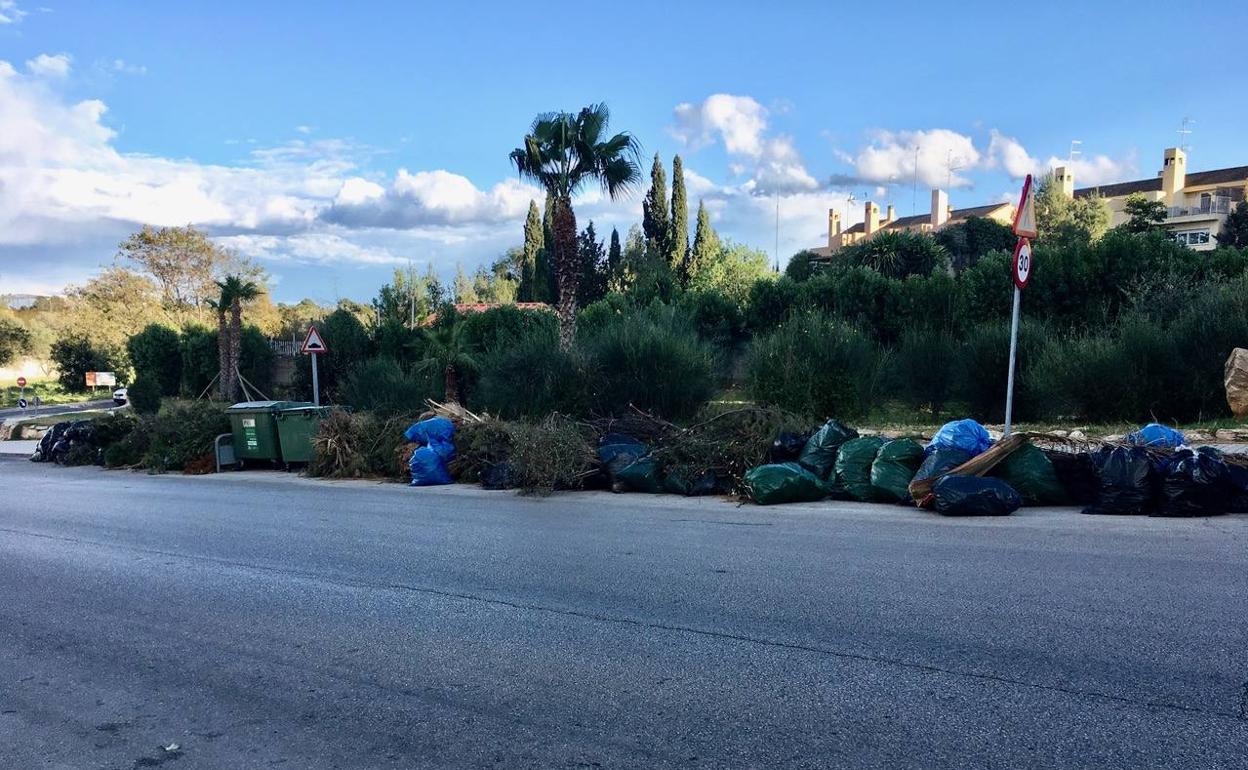 La calle Acacias con los restos de poda, junto a los contenedores. 