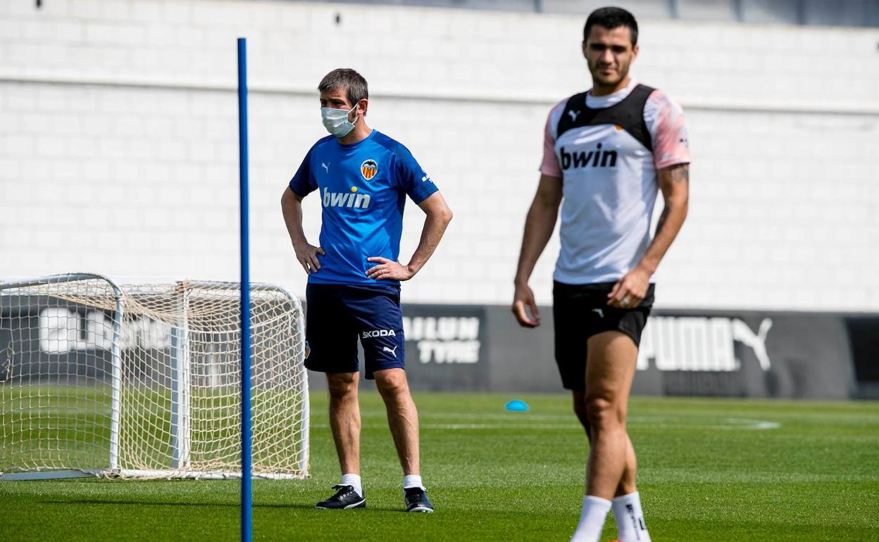 Celades, atento a una jugada de un entrenamiento con Maxi Gómez en primer plano. 